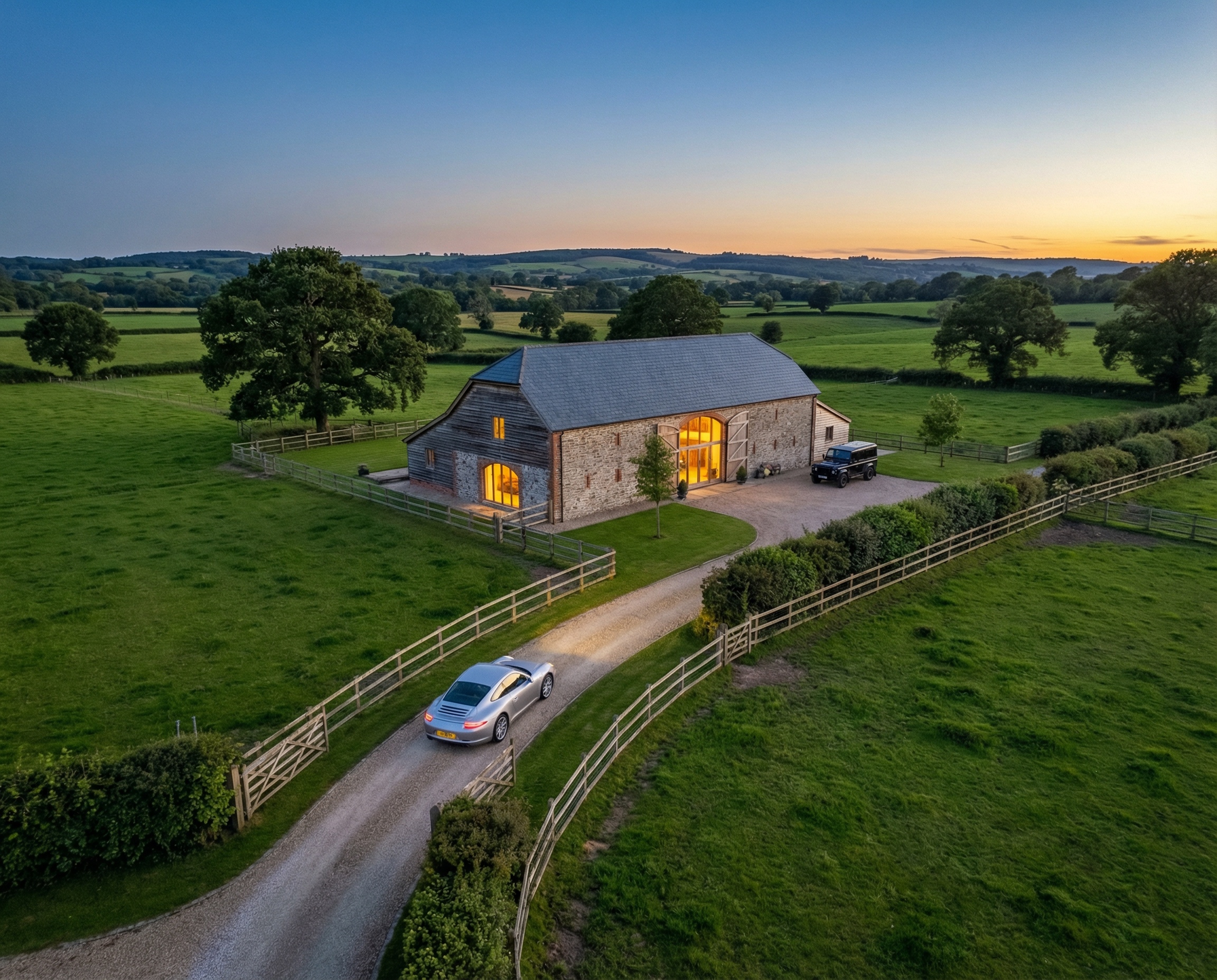 Aerial view of a countryside barn conversion with vehicles