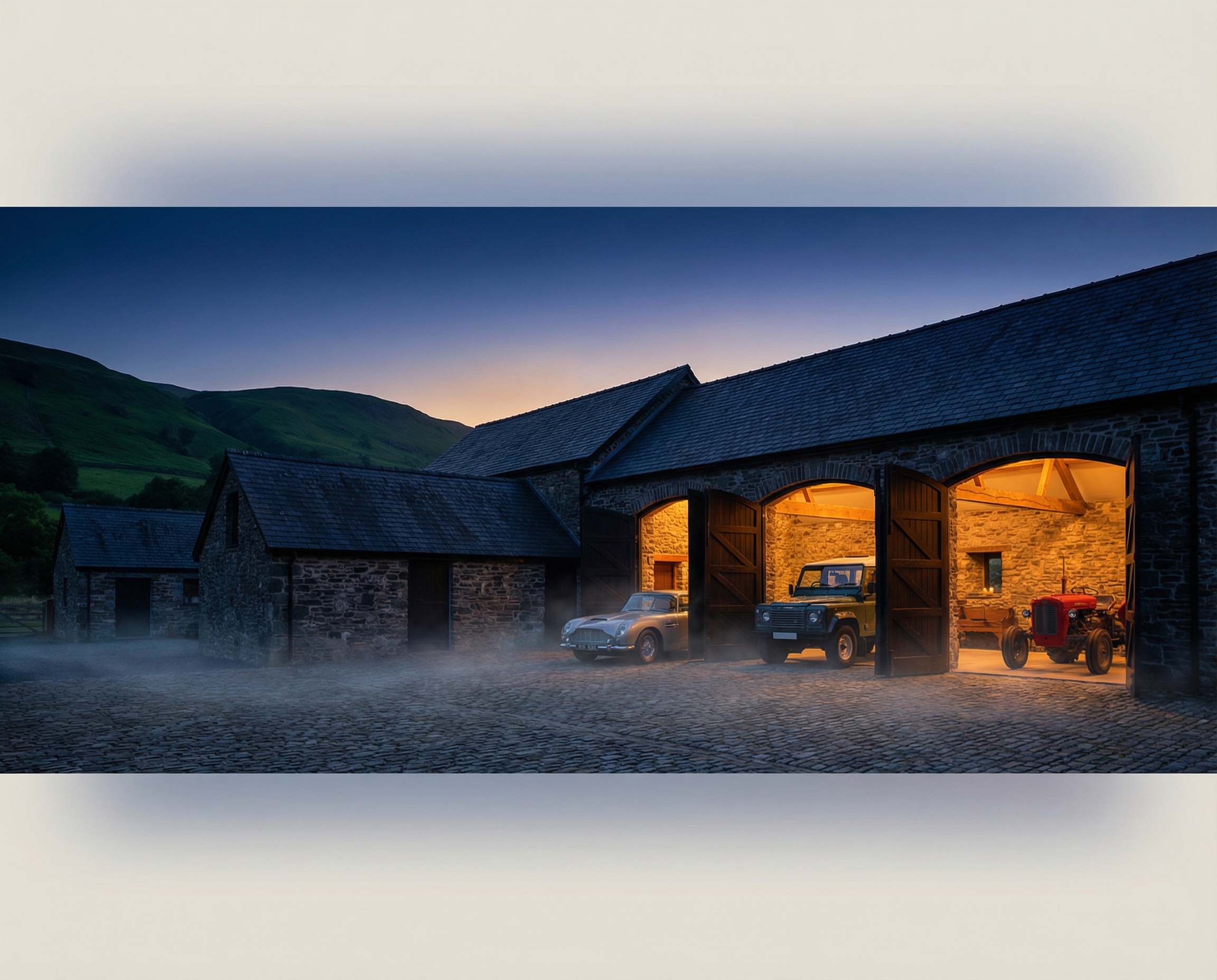 Stone barn complex at twilight with warm interior lighting
